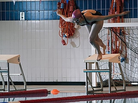 female swimmer diving into swimming pool