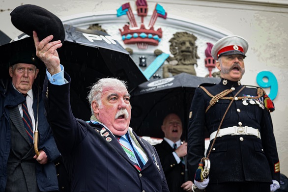 Veterans brave the rain to cheer the raising of the Falklands flag on Plymouth Hoe