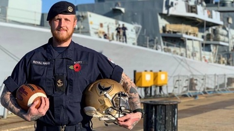 royal navy sailor standing with kit by vessel