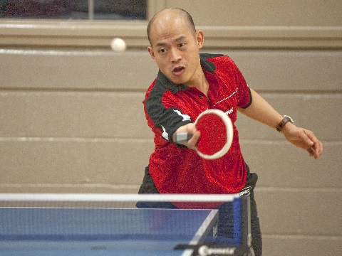 red shirted table tennis player returning with backhand