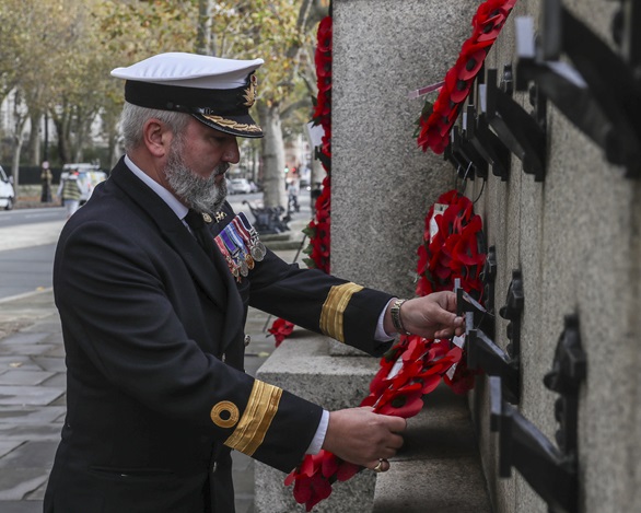 Commodore Jim Perks hangs a wreath on the memorial