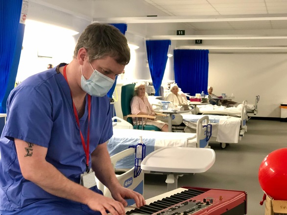Patients listen to a Royal Marines musician performing keyboard in Exeter