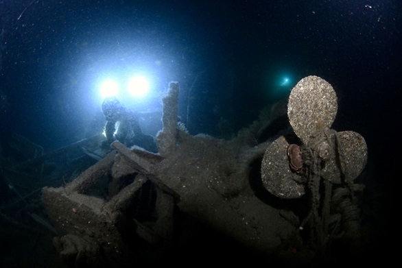 Light shines on the propeller of the wreck