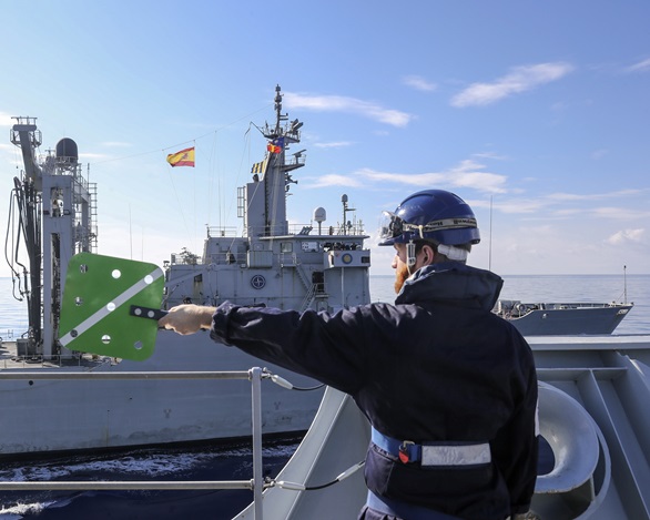A seamanship specialist signals from HMS Albion to tanker ESPS